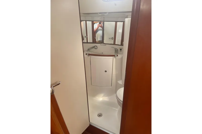 Kasoumai Yacht Photos Pics Bathroom interior of 2007 Beneteau 423 yacht, featuring compact design and mirrored cabinets.