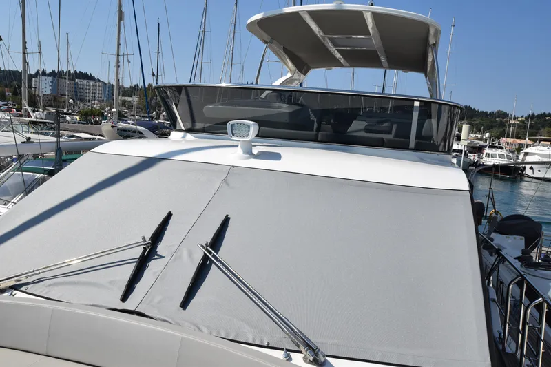 Ocean Love Yacht Photos Pics 2023 Absolute 50 Fly yacht with covered windshield in marina setting.