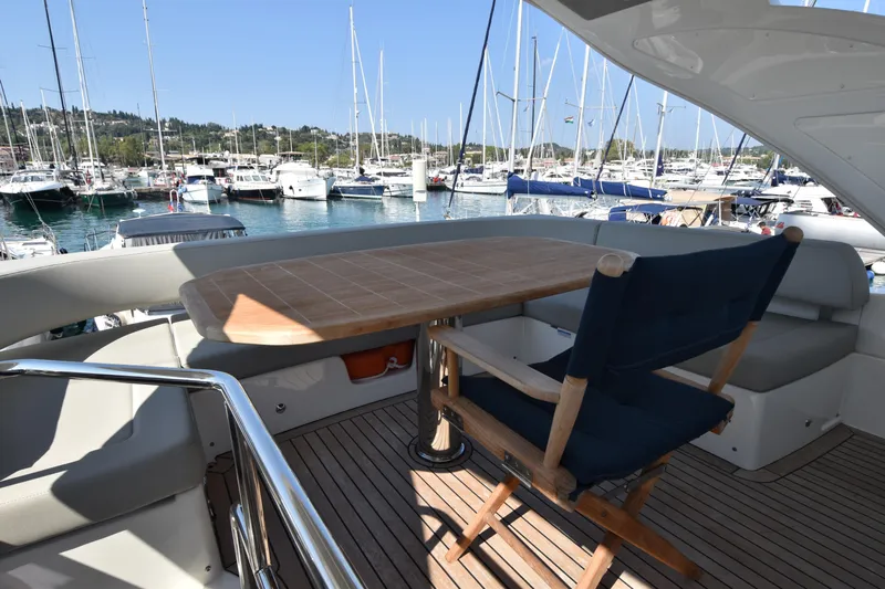 Ocean Love Yacht Photos Pics 2023 Absolute 50 Fly yacht deck with table and chair, overlooking marina.