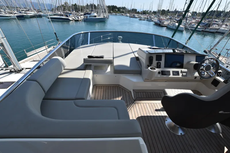 Ocean Love Yacht Photos Pics Flybridge of 2023 Absolute 50 Fly yacht with modern helm and seating, docked in marina.