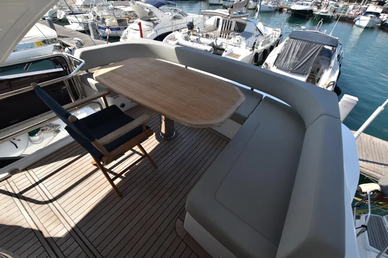 Ocean Love Yacht Photos Pics Luxurious 2023 Absolute 50 Fly yacht deck with seating and table, docked in marina.