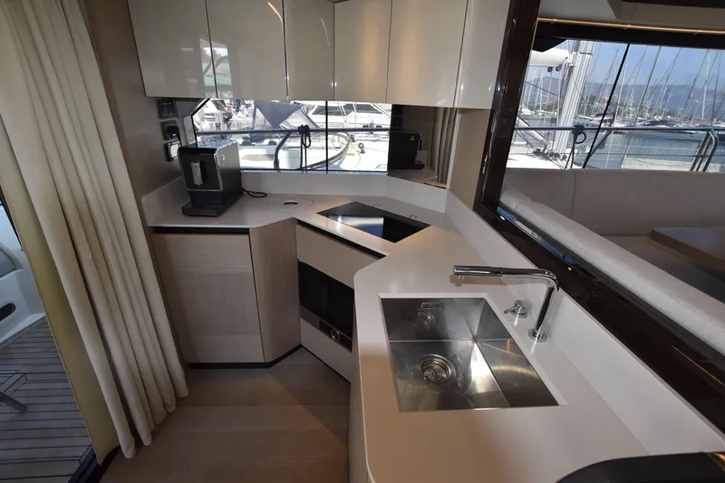 Ocean Love Yacht Photos Pics Modern kitchen interior on 2023 Absolute 50 Fly yacht, featuring sleek cabinetry and stainless steel sink.