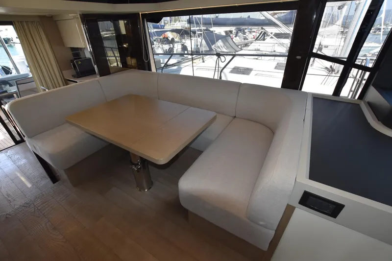 Ocean Love Yacht Photos Pics Luxurious interior of 2023 Absolute 50 Fly yacht with elegant dining area and panoramic windows.