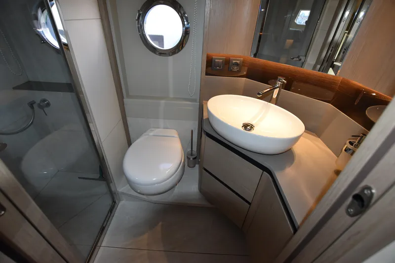 Ocean Love Yacht Photos Pics Luxurious bathroom in 2023 Absolute 50 Fly yacht with modern fixtures and porthole window.
