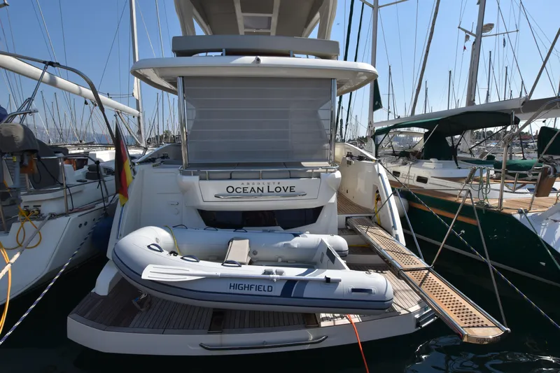 Ocean Love Yacht Photos Pics 2023 Absolute 50 Fly yacht with dinghy, docked in a marina.