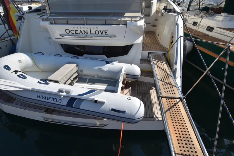 Ocean Love Yacht Photos Pics 2023 Absolute 50 Fly yacht with inflatable Highfield boat docked at marina.