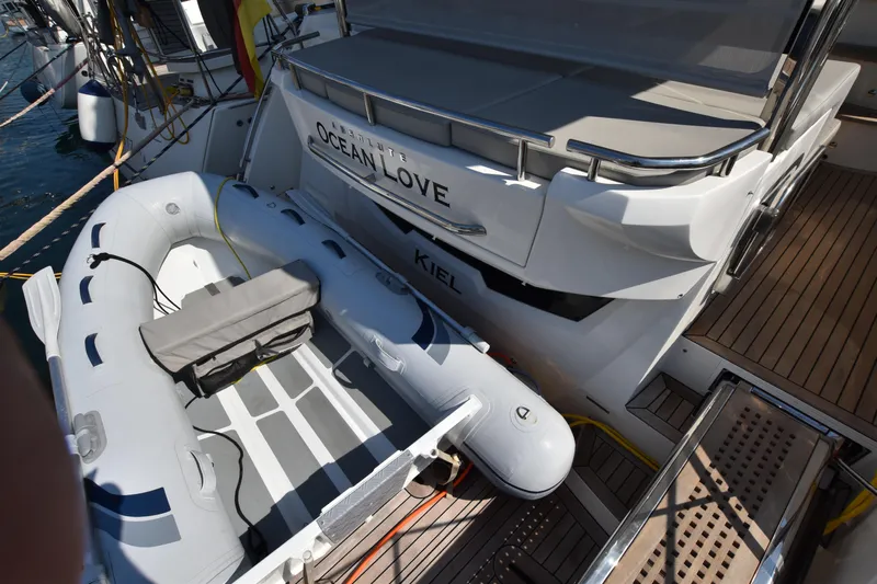 Ocean Love Yacht Photos Pics 2023 Absolute 50 Fly yacht with inflatable dinghy on deck, docked at marina.