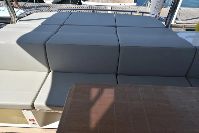 Ocean Love Yacht Photos Pics Luxurious seating area on 2023 Absolute 50 Fly yacht, featuring elegant cushions and wooden table.