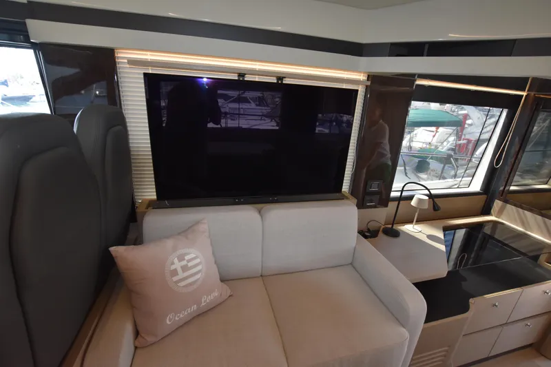 Ocean Love Yacht Photos Pics Interior of 2023 Absolute 50 Fly yacht with sofa, TV, and window views.