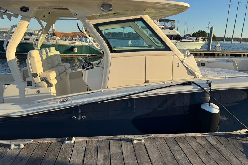  Yacht Photos Pics 2025 Scout 357 LXF boat docked at marina, showcasing sleek design and luxury seating.
