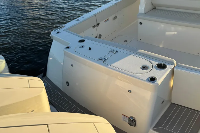  Yacht Photos Pics 2025 Scout 357 LXF boat deck with seating and storage, on calm water.