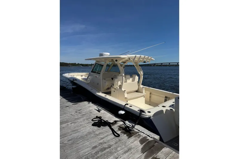  Yacht Photos Pics 2025 Scout 357 LXF boat docked by the water on a sunny day.