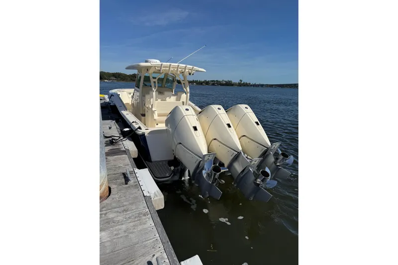  Yacht Photos Pics 2025 Scout 357 LXF boat docked with triple outboard engines.