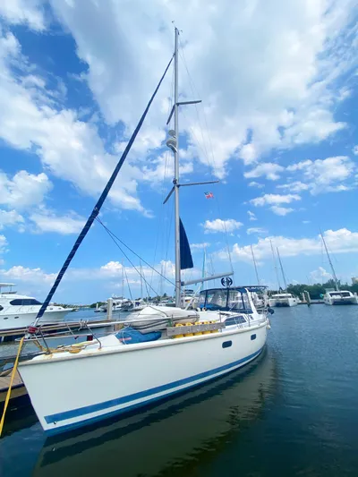 5th Row Center Yacht Photos Pics 1997 Hunter 430 sailboat docked in a marina under a partly cloudy sky.