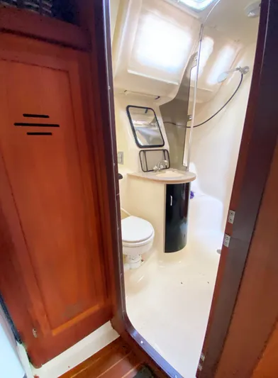 5th Row Center Yacht Photos Pics Interior of 1997 Hunter 430 sailboat bathroom with shower and wooden cabinetry.