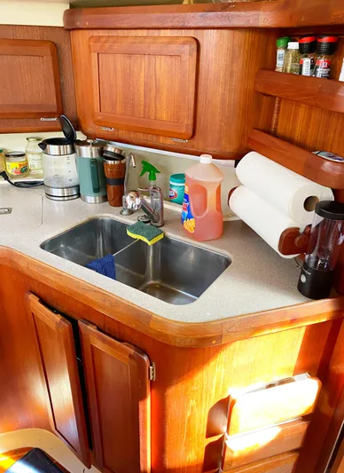 5th Row Center Yacht Photos Pics 1997 Hunter 430 yacht kitchen with wooden cabinets, sink, and countertop appliances.
