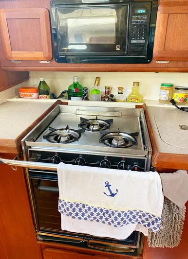 5th Row Center Yacht Photos Pics 1997 Hunter 430 yacht kitchen with stove, microwave, and nautical-themed towel.