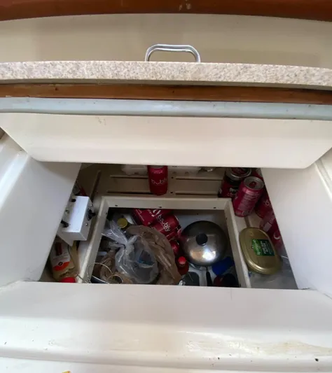 5th Row Center Yacht Photos Pics Storage compartment in a 1997 Hunter 430 yacht, filled with cans and kitchen items.