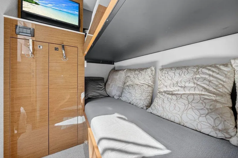  Yacht Photos Pics 2020 Cruisers Yachts 50 Cantius interior cabin with cozy bedding and wall-mounted TV.