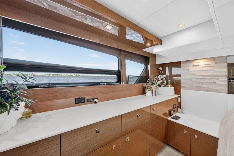  Yacht Photos Pics Luxurious interior of 2020 Cruisers Yachts 50 Cantius with elegant wood cabinetry and scenic window view.