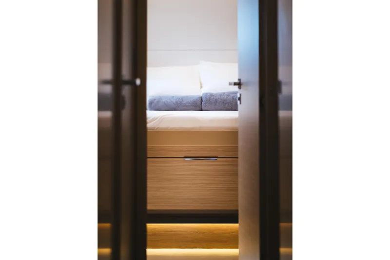 Catwalk Yacht Photos Pics Luxurious cabin interior of 2023 Lagoon LAGOON 51 yacht, featuring elegant bedding and ambient lighting.