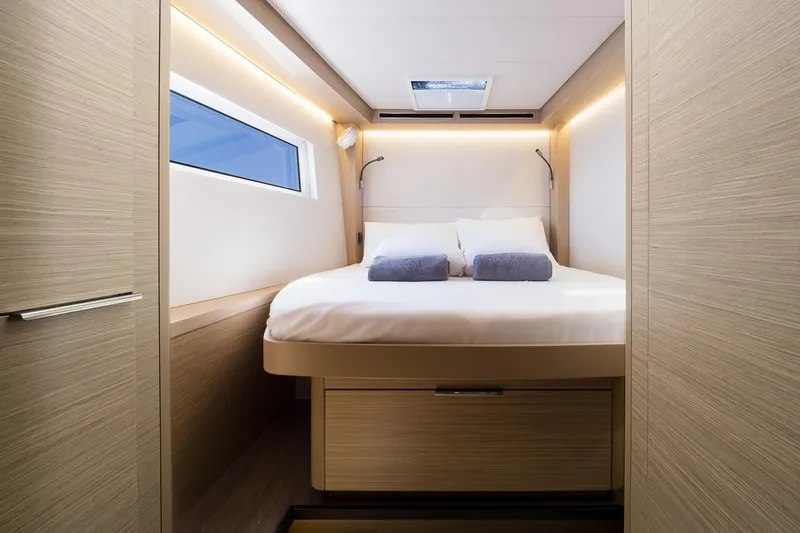 Catwalk Yacht Photos Pics Luxurious cabin interior of 2023 Lagoon LAGOON 51 yacht with modern design and cozy bedding.