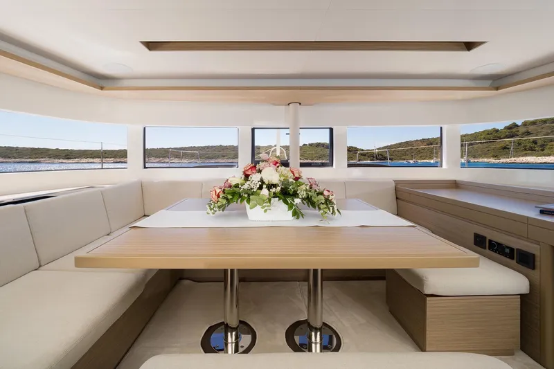 Catwalk Yacht Photos Pics Luxurious interior of 2023 Lagoon LAGOON 51 yacht with elegant dining area and floral centerpiece.