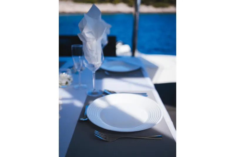 Catwalk Yacht Photos Pics Elegant dining setup on Lagoon 51 yacht, 2023, with ocean view.