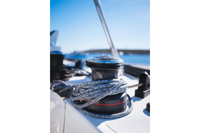 Catwalk Yacht Photos Pics Winch and rope on 2023 Lagoon LAGOON 51 yacht deck under clear blue sky.