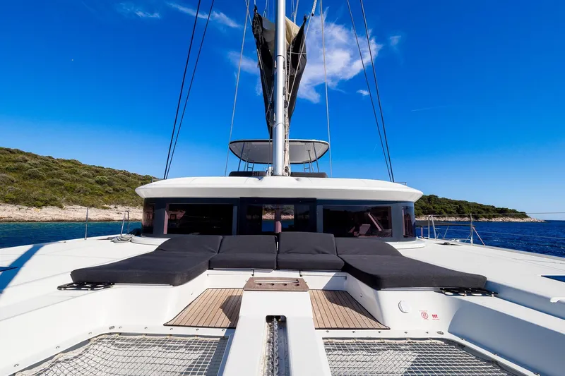 Catwalk Yacht Photos Pics 2023 Lagoon LAGOON 51 yacht with sunbathing area, sailing in clear blue waters.