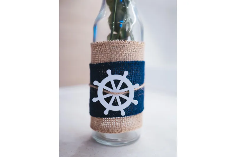 Catwalk Yacht Photos Pics Decorative bottle with nautical theme, featuring a ship wheel design and burlap wrap.