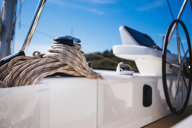 Catwalk Yacht Photos Pics Close-up of 2023 Lagoon LAGOON 51 yacht deck with ropes and steering wheel.