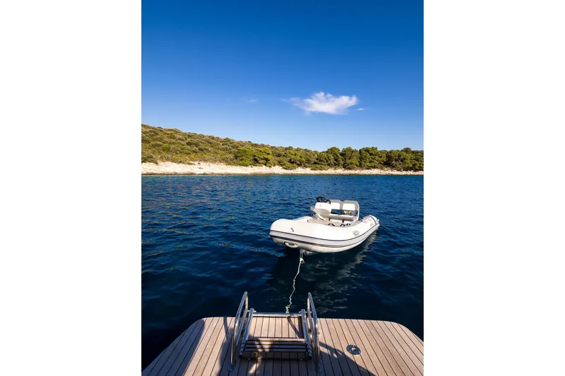 Catwalk Yacht Photos Pics 2023 Lagoon LAGOON 51 yacht with tender boat on serene blue water.