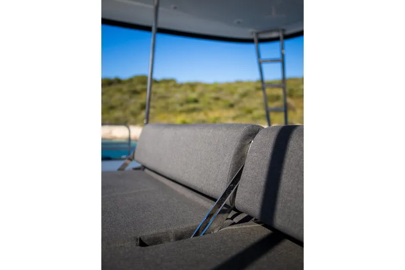 Catwalk Yacht Photos Pics Gray seating on 2023 Lagoon LAGOON 51 yacht with ladder and scenic background.