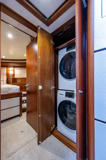 Uncorked Yacht Photos Pics Laundry area with stacked washer and dryer in 2011 Ocean Alexander 85E yacht interior.