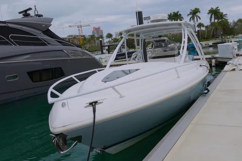  Yacht Photos Pics 2014 Intrepid 327 Cuddy boat docked at marina with palm trees in background.