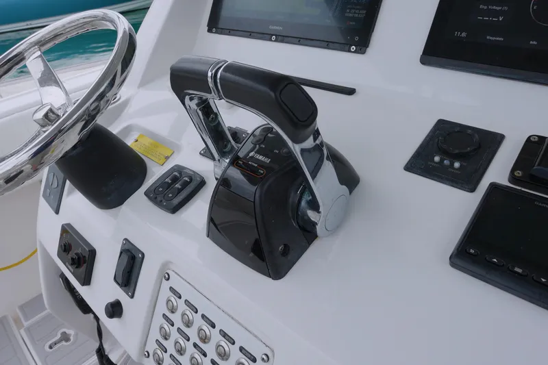  Yacht Photos Pics Control panel of a 2014 Intrepid 327 Cuddy boat with steering wheel and throttle.