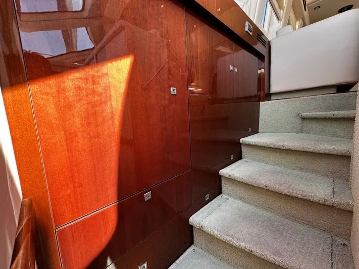 Incentive Yacht Photos Pics Interior stairs of 2008 Sea Ray 47 Sedan Bridge with wooden paneling and carpeted steps.