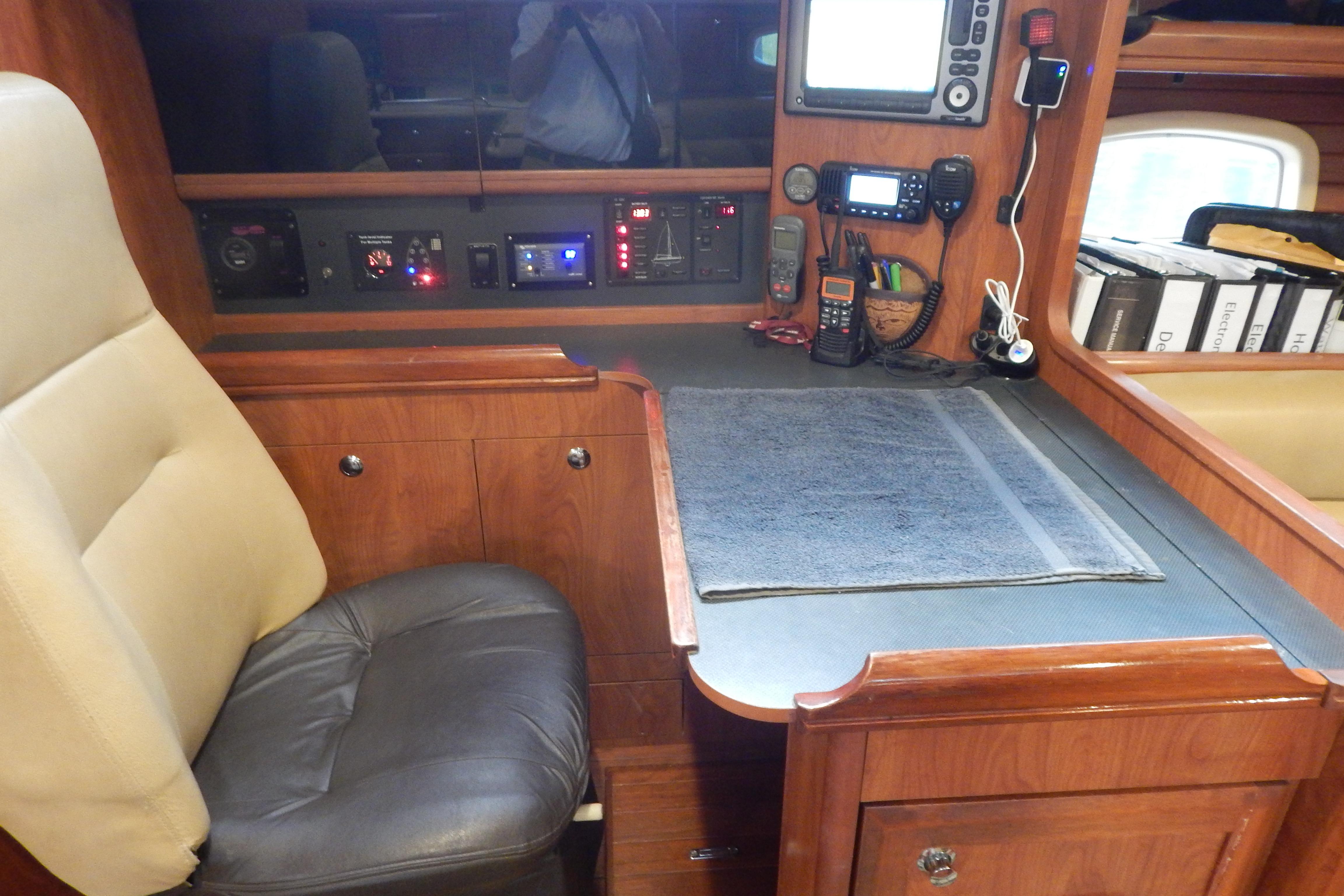 Navigation station in 2010 Hunter Sailing Diver yacht with control panels and seating.