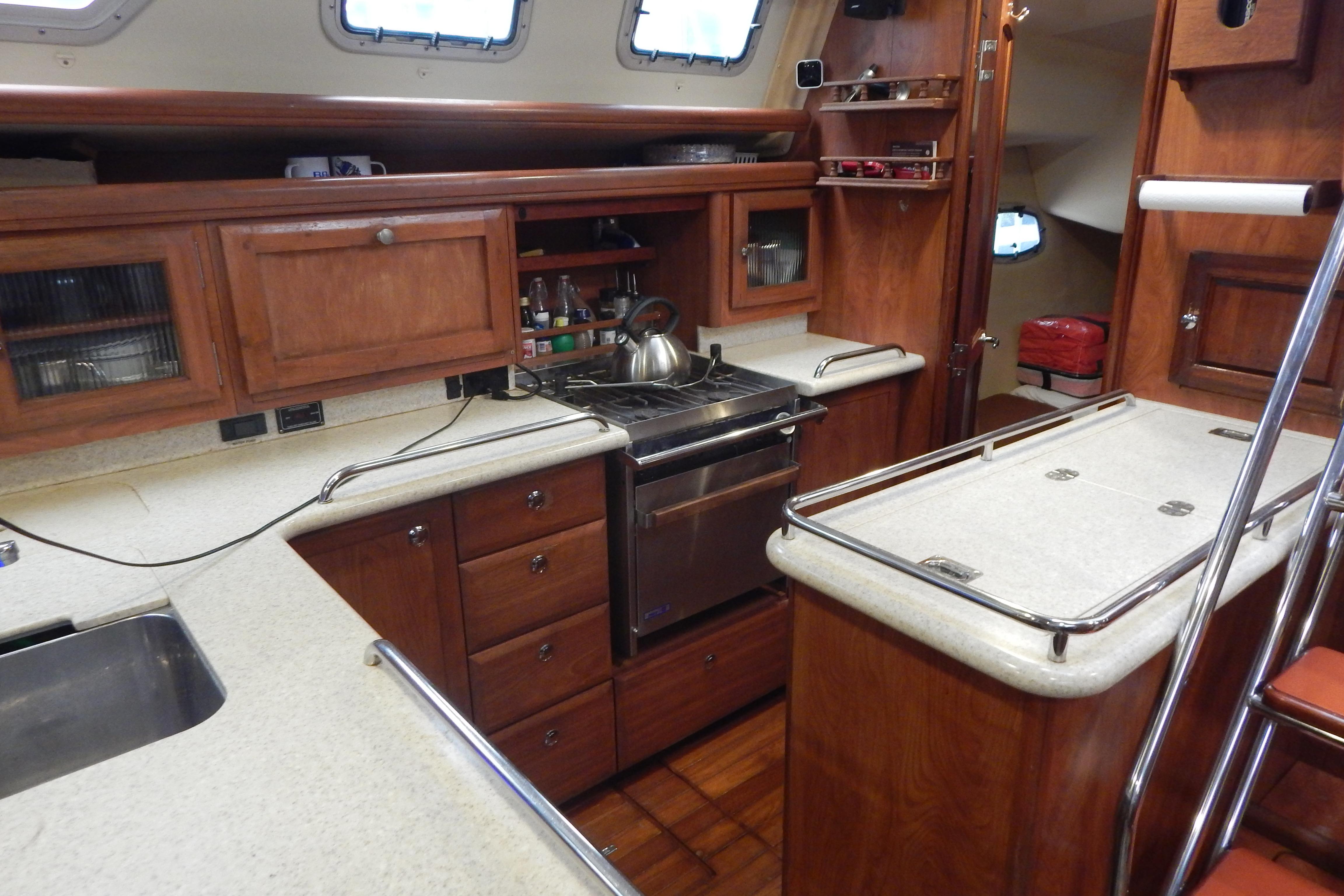 2010 Hunter Sailing Diver yacht kitchen with wooden cabinets and modern appliances.
