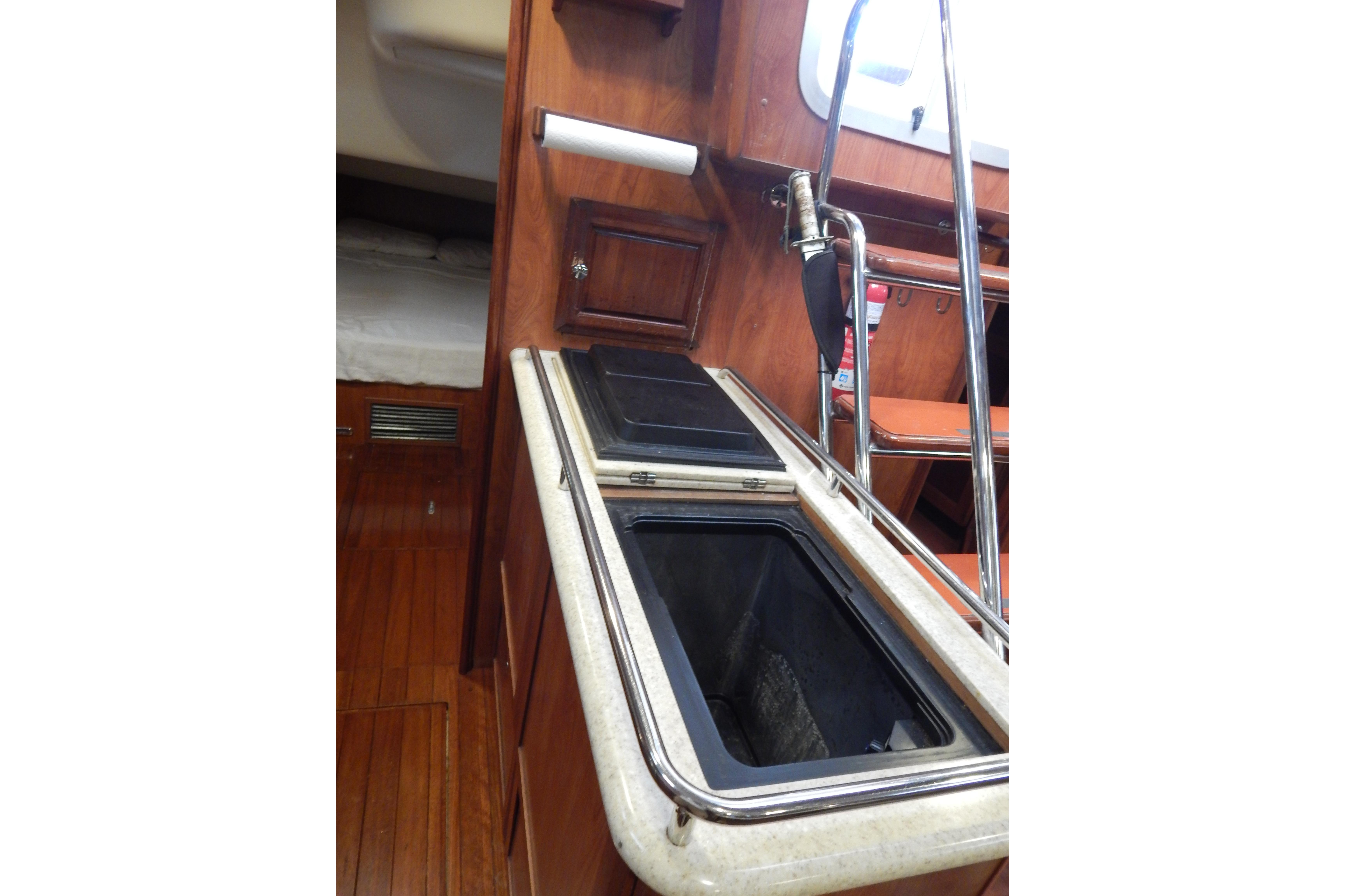 Interior of 2010 Hunter Sailing Diver yacht with wooden cabinetry and stainless steel fixtures.