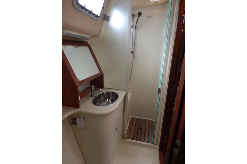  Yacht Photos Pics 2010 Hunter Sailing Diver bathroom with sink, shower, and wooden accents.