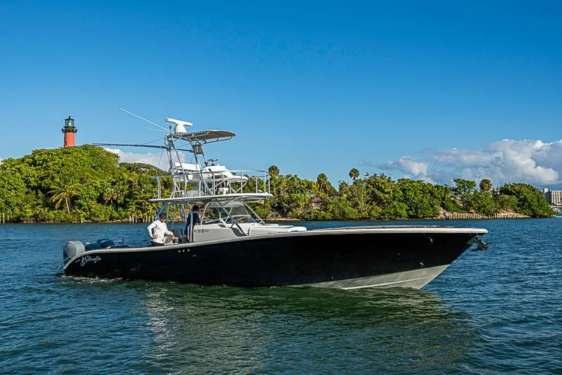  Yacht Photos Pics 2010 Yellowfin 42 Offshore boat cruising near lush island and lighthouse.