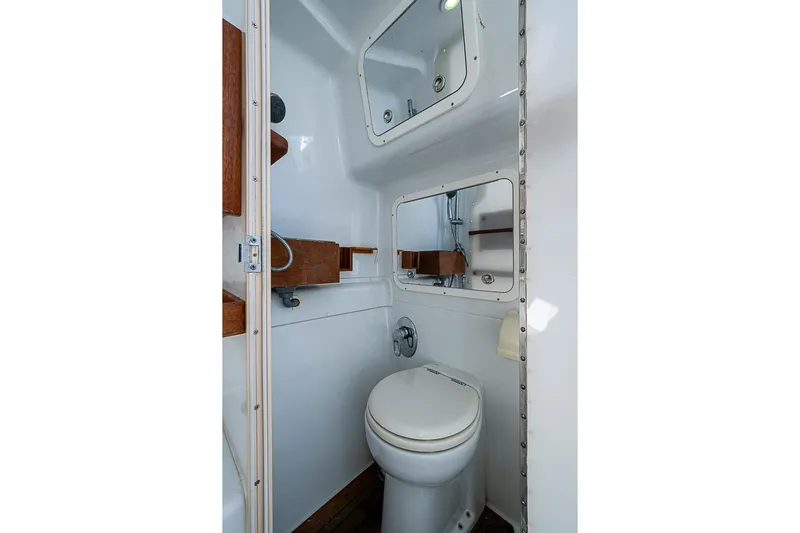 Yacht Photos Pics 2010 Yellowfin 42 Offshore boat bathroom with toilet, mirrors, and wooden shelves.