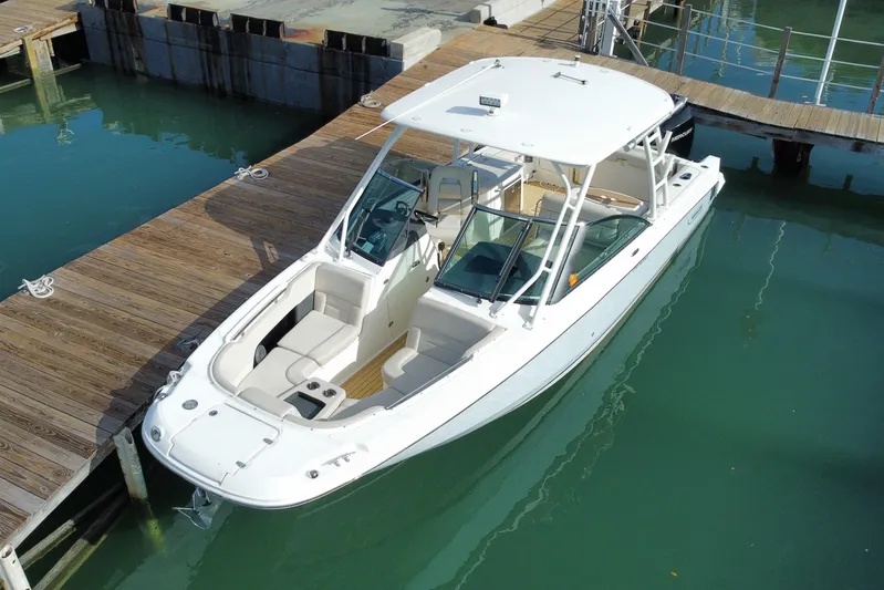  Yacht Photos Pics 2019 Boston Whaler 270 Vantage docked in clear water, showcasing sleek design and spacious seating.