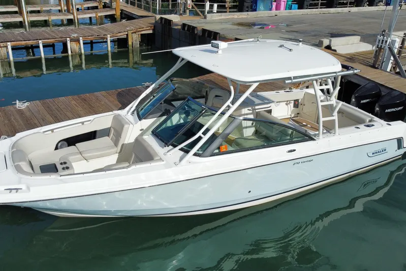 Yacht Photos Pics 2019 Boston Whaler 270 Vantage boat docked at marina, featuring sleek design and spacious seating.