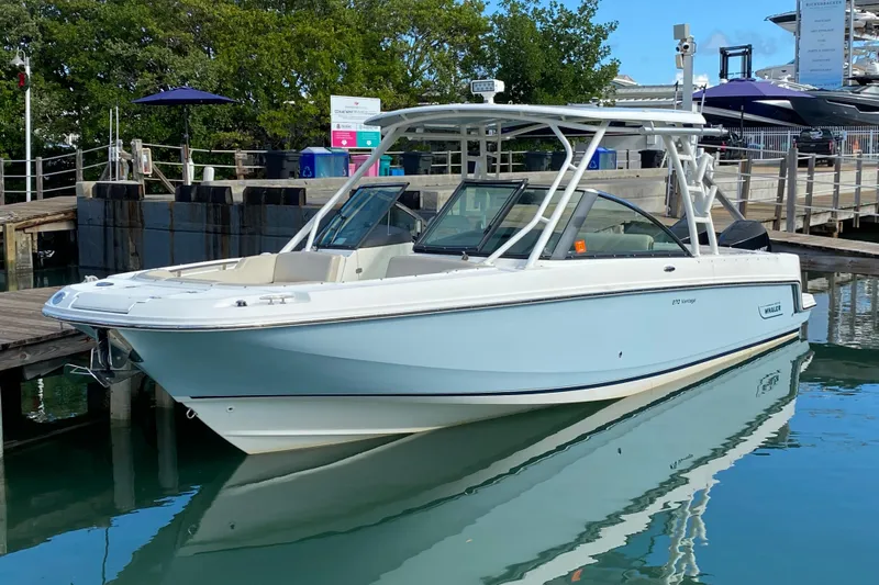  Yacht Photos Pics 2019 Boston Whaler 270 Vantage boat docked in a marina, reflecting on calm water.