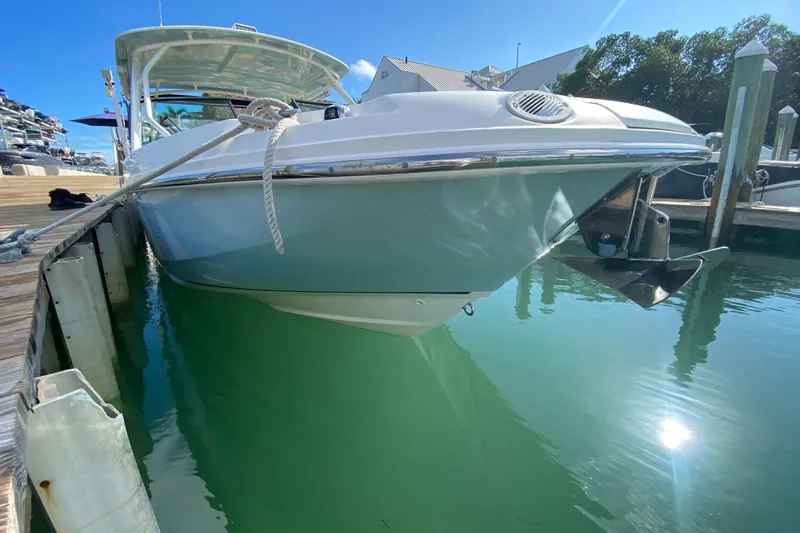  Yacht Photos Pics 2019 Boston Whaler 270 Vantage docked, reflecting on clear blue water.