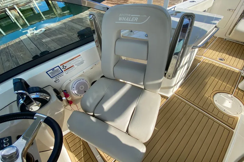  Yacht Photos Pics 2019 Boston Whaler 270 Vantage helm seat and controls, featuring teak flooring.
