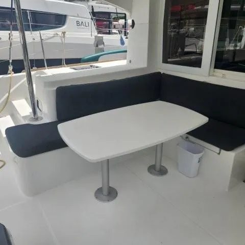 Manuia Yacht Photos Pics Outdoor seating area on a 2019 Lagoon 40 catamaran with a white table.